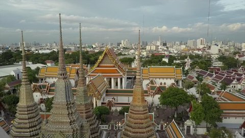 Wat Phra Kaew temple in Bangkok beautiful drone view in 4K. Aerial shot of amazing Thai Buddhist temple. Unique perspective close over golden roof and skyline background. Wat Pho