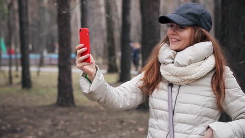Young Woman making a video call with her smartphone at park