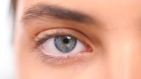 Beautiful human eye close-up. Young Woman Blue one eye macro shoot. Macro Closeup eye blinking, isolated on white background. 4K UHD video
