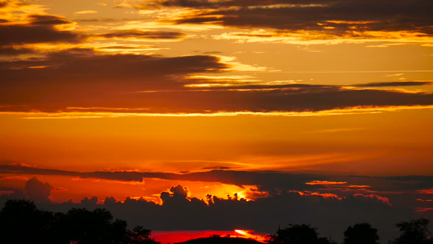 Dramatic sunset with orange clouds. Beautiful sky with multicolored cloudscape while dusk
