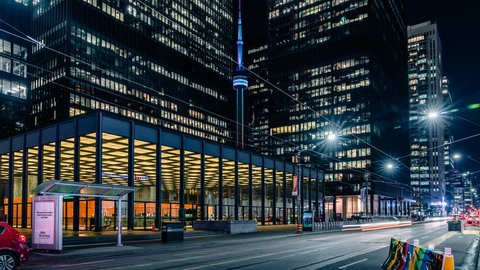 Toronto, Ontario / Canada - June 2 2018: Time lapse of the modern and futuristic Toronto financial district with smooth beautiful car traffic light streaks and epic architecture. Cn Tower and TD bank.