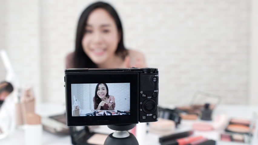 Young beautiful Asian woman professional beauty vlogger or blogger recording make up tutorial video with camera | Shutterstock HD Video #1012173704