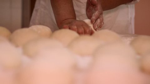 Making pizza or pide dough by close up male hands in pastry kitchen. Shaping dough is precursor to making a wide variety of food stuffs, particularly breads
