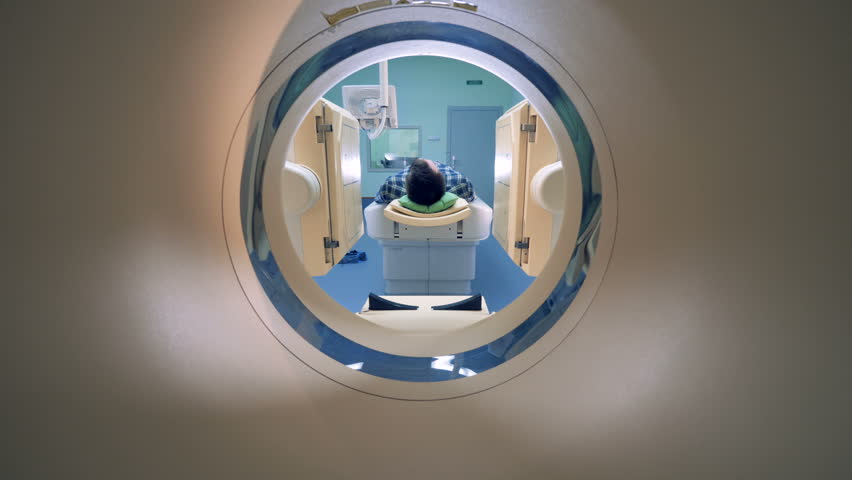 Male patient is moving into a CAT-scanner. Medical equipment: computed tomography machine in diagnostic clinic Royalty-Free Stock Footage #1012183874