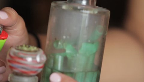 Someone smoking out of a bong