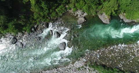 Alpine river seen from above. In summer the river gets thicker due to the thaw of the glaciers. Top view of the river Sesia in Piedmont, Italy.