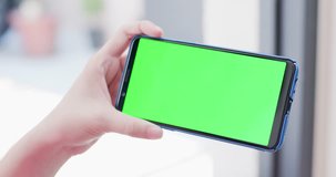 woman take cell phone with green screen