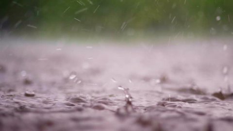 close-up, large, heavy drops of rain, rainfall, shower, fall with a spray, Water splashes, on the wet surface of puddles, the surface of water. big drops from the rain on wet floor texture