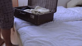 A man packs a suitcase on vacation, slow motion video