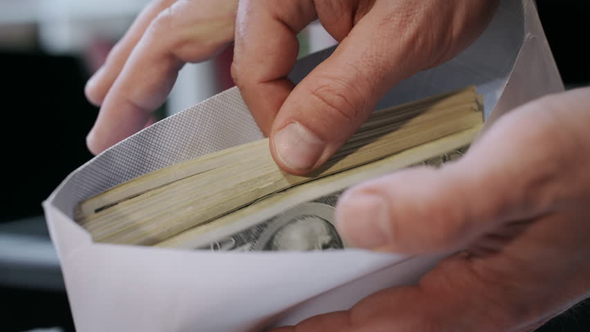 Close up of cash money in envelope in hands. Money bonus in paper envelope. Man holding envelope with dollar bills. World bribery. Scam and corruption concept. Credit company financial services Royalty-Free Stock Footage #1012198736
