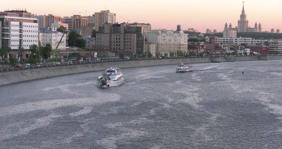 4K high quality spring evening sunset video footage of Moscow city skyline and panorama of buildings, boats sailing on the Moskva River and embankment near city center in the capital of Russia