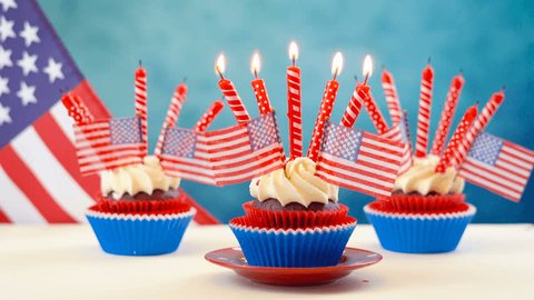 Red white and blue theme cupcakes with USA flags for Independance Day or USA theme party food.