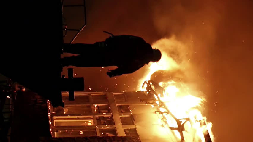 House building on fire at night. Inferno conflagration. Fireman fights fire. Vertical format video.