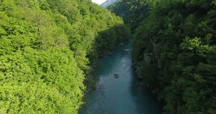 Aerial view of a group of people rafting on a green river
