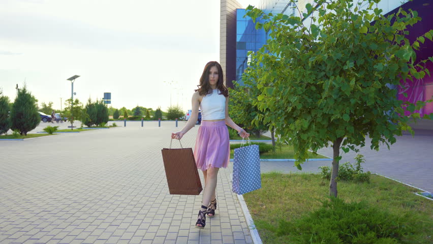 Happy client walks with purchases near shopping mall and dances Royalty-Free Stock Footage #1012210583