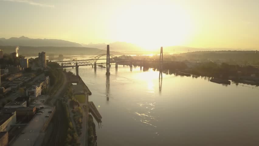 Aerial view of Fraser River and Bridges during a vibrant sunrise. Taken in New Westminster, Greater Vancouver, British Columbia, Canada.