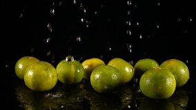 HD Super Slow-Mo: Water Drops Falling On A Lime. Front view.