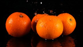 HD Super Slow-Mo: Water Drops Falling On An Orange. Front view.