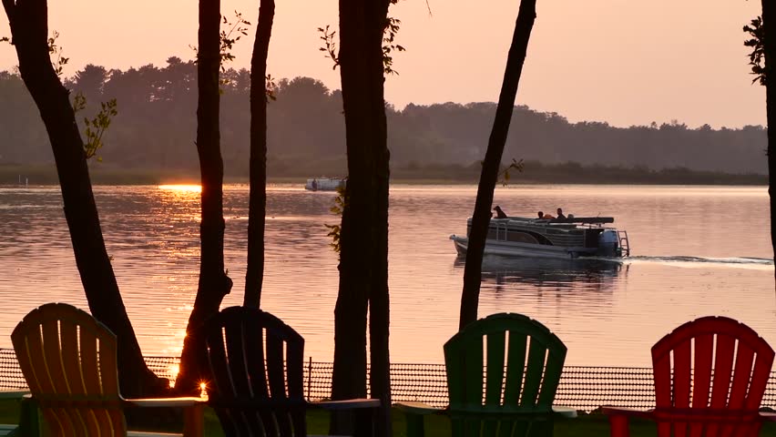 Pontoon with couple and dog on beautiful Lake Irving in Bemidji Minnesota at sunset