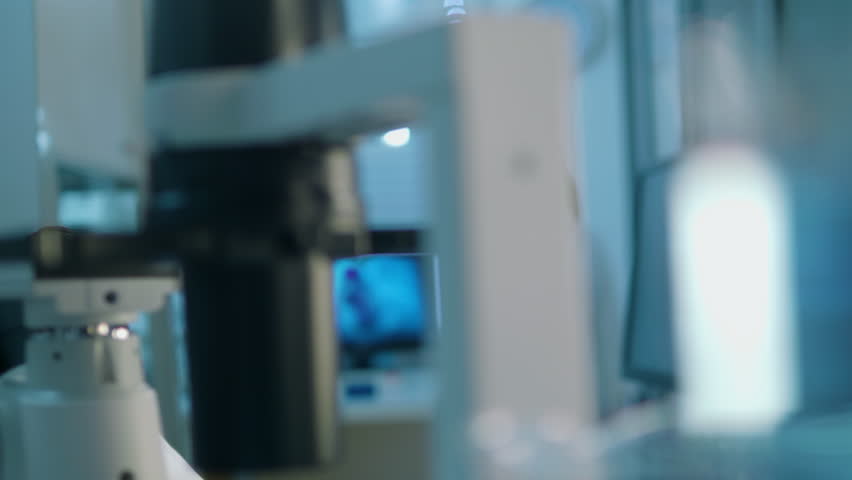 Life scientist working at a laboratory. Young indian male life scientist looking at samples through microscope. Royalty-Free Stock Footage #1012236710
