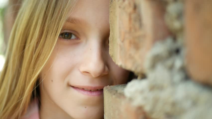 Sad Child Face Playing Hide and Seek, Scared Girl Behind Walls Smiling in Camera