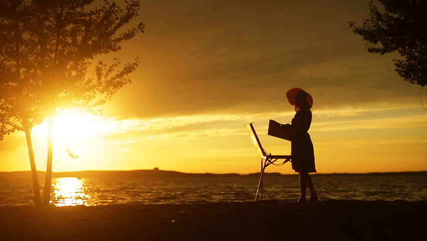 Painter making a picture closeup at sunset silhouette