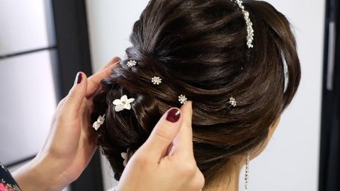Beauty wedding hairstyle. Bride. Brunette girl with curly hair styling with barrette.