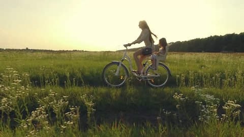 Mother and daughter have bike ride on nature. Summertime activity. Aerial
