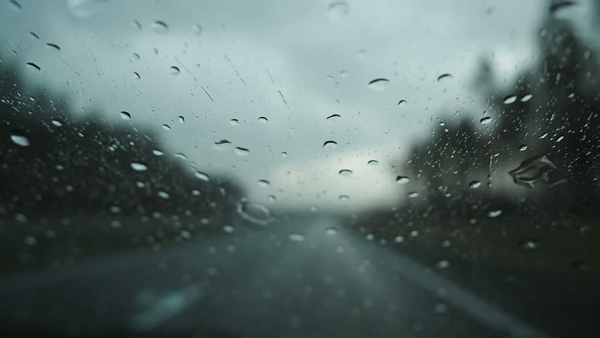 Driving in the rain view from inside car with rain drops on car windshield. Rain drops on window car windshield Royalty-Free Stock Footage #1012277996