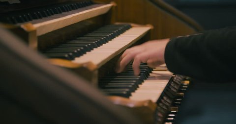 Detail of a man playing a church organ.