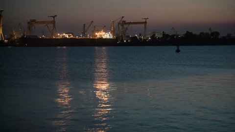 Floating cranes in port at night