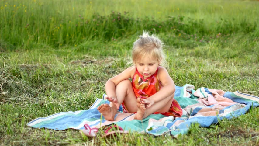 child sits on grass: Stockvideók (100%-ban jogdíjmentes) 20373199 Shutterst...