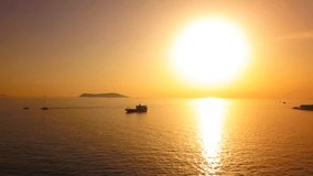 Time Lapse Flying over a landing boat against the sun. Silhouette of the bulk carrier ship sailing into Marmara Sea at sunset. View from aerial camera
