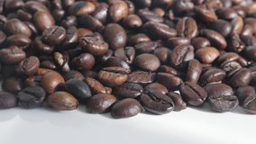 Slow tilt on roasted coffee beans on pile 4K footage