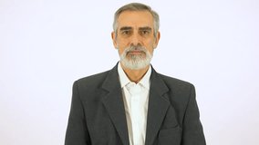 An elderly man taps his watch and nods at the camera - white screen studio - Powered by Shutterstock - Get 15% off with code: PIKWIZARD15