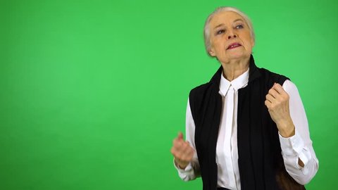 An elderly woman acts frustrated - green screen studio