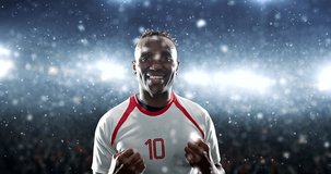 Soccer player celebrates a victory and raises arms happily on the professional stadium while it is snowing. Stadium and crowd are made in 3D and animated.
