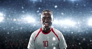 Soccer player celebrates a victory and raises arms happily on the professional stadium while it is snowing. Stadium and crowd are made in 3D and animated.