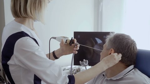 Doctor examine ear of patient with ENT telescope