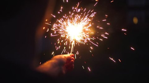 ?rowd of young happy people with sparklers. Sparkler in hands on wedding bride, groom and guests holding lights in hand closeup. Sparkling lights bengal fires. New Year 2020