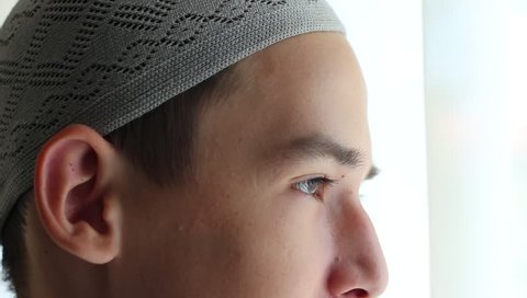 Moroccan guy. Eyes close-up. Portrait of a arabic muslim teen wearing a traditional hat
