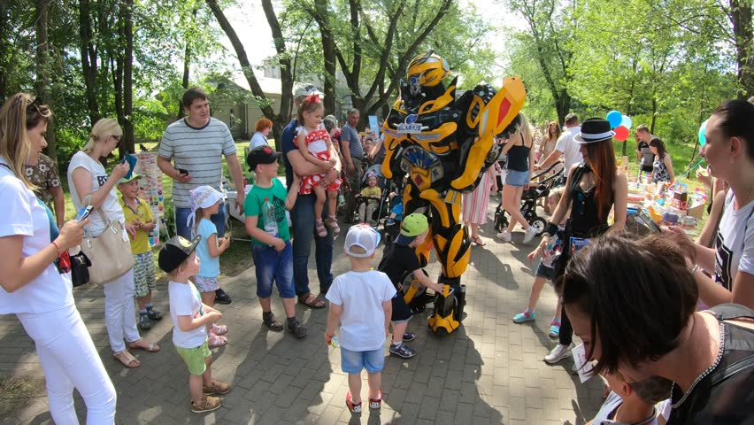 Minsk, Belarus, June 3, 2018: Animator in a suit of robot transformer among children in a city park.