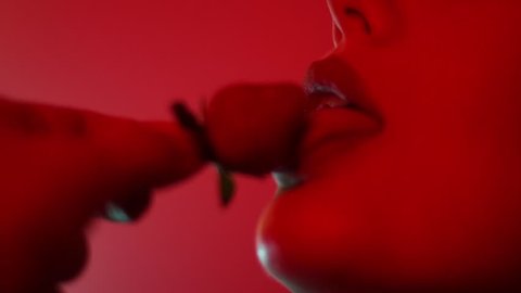 Woman sexy eating a strawberry at night. Couple games.