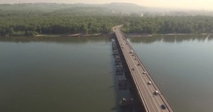 Aerial view. Bridge with traffic over the river w on a sunny day in small city. 4K