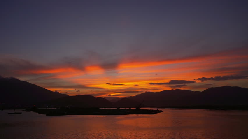 Amazing sunset view of mountains silhouette at the lake rapid slow motion