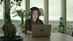 Young Asian Woman Watching Music Video on Computer at Home