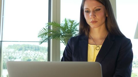 Corporate Female Entrepreneur Using Laptop Computer in Home Office Searching Web