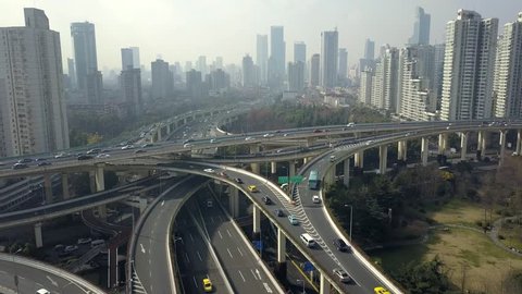 Shanghai China Road Junction traffic cars Elevated overpass complicated urban interchange Technology multilevel modern technological construction Skyscrapers cityscape fog day. Aerial Approach to 4k