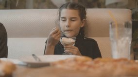 little girl eating ice cream at a fast food cafe slow motion video. Kid eating ice cream in cafe. Funny curly child with ice cream outdoor. girl eating ice lifestyle cream concept