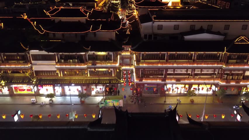 Night illumination Yuyuan Garden Shanghai China bright multicolored people tourists walking pedestrian Old Ancient street trading market historical culture Travel attraction sight. Helicopter Forward